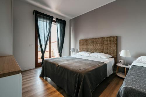 Habitación de hotel con cama y ventana en Mistral Apartments, en Puntone di Scarlino
