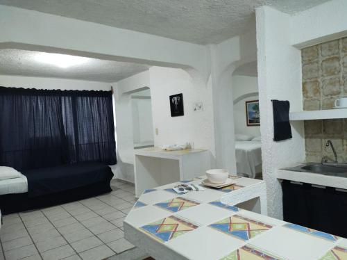 cocina y sala de estar con sofá y mesa en Íkaro Suites Cancún, en Cancún