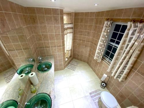 a bathroom with two sinks and a toilet at Marina View Villa in Gros Islet