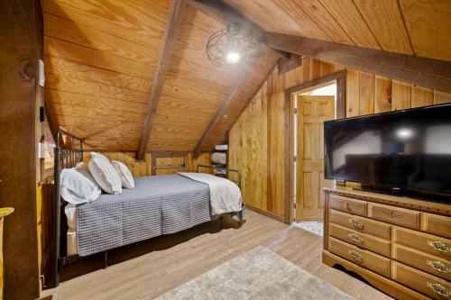 a bedroom with a bed and a flat screen tv at New Listing Forest Footprints in Big Canoe in Afton