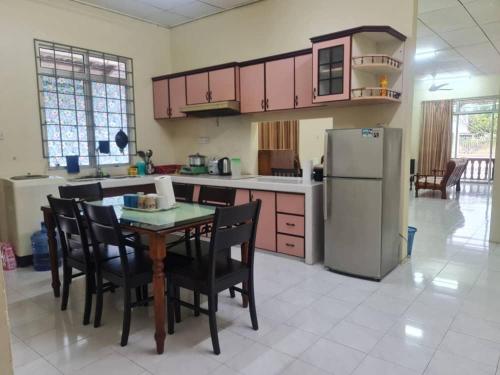 a kitchen with a table and chairs and a refrigerator at Paka Seaview Inn in Paka