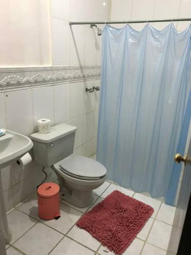a bathroom with a toilet and a blue shower curtain at Excelente casa a unos pasos del blvd M. Alemán in Gómez Palacio