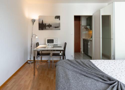 a bedroom with a desk and a table with a computer at Modern studios in the heart of Lausanne in Lausanne