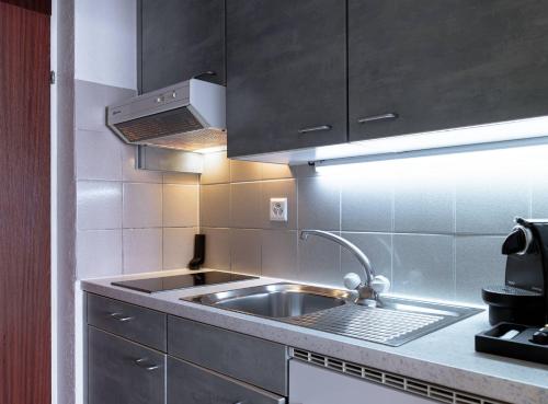 a kitchen with a sink and a stove at Modern studios in the heart of Lausanne in Lausanne