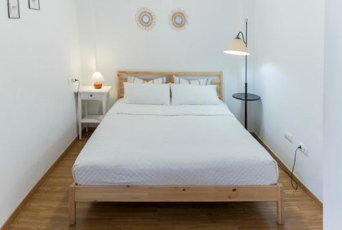 een slaapkamer met een groot bed met witte lakens bij San Justo 3 in Huelva