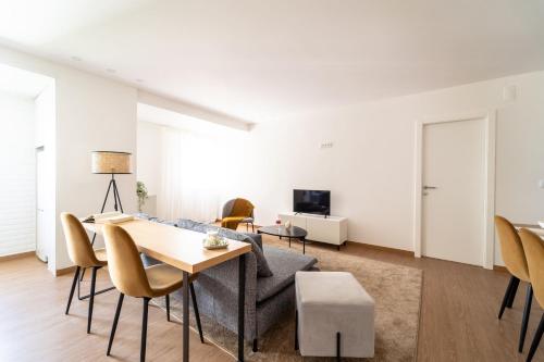 a living room with a table and chairs and a couch at Feliciano Ramos 3 - T4 familiar perto do centro da cidade - Braga in Braga