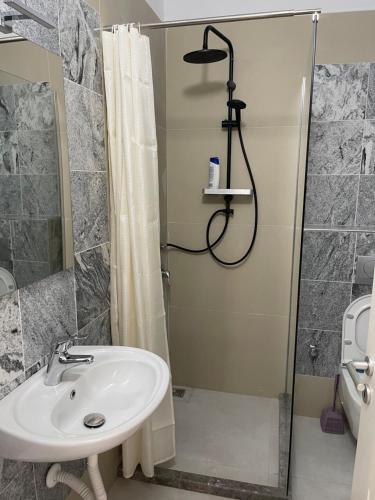 een badkamer met een wastafel en een douche bij Fishta hotels in Velipojë