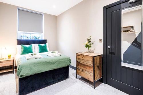 a bedroom with a bed with green pillows and a window at Wiverton Apt #4 - Central Location - Free Parking, Fast WiFi and Smart TV by Yoko Property in Nottingham