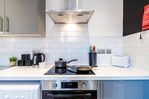 a kitchen with a stove with a pot on it at Wiverton Apt #4 - Central Location - Free Parking, Fast WiFi and Smart TV by Yoko Property in Nottingham