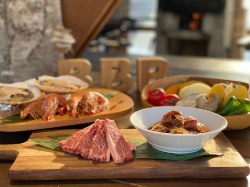 a table with plates of food and a bowl of meat at Wakka BBB in Teshikaga