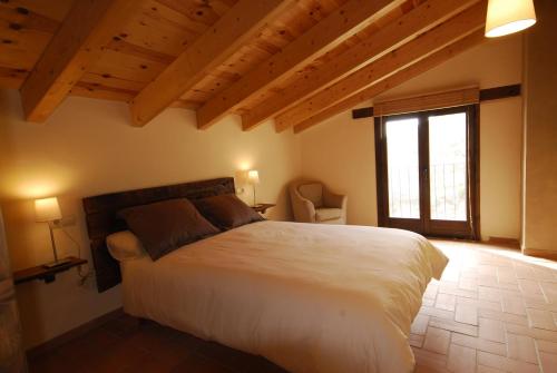 a bedroom with a large bed and a window at O Chardinet d'a Formiga in Aínsa