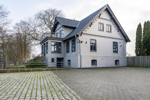 a large white house with a driveway in front of it at Buchenhof in Delingsdorf
