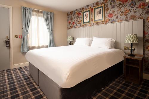 a large white bed in a room with a window at The Stables - The Inn Collection Group in Whitby