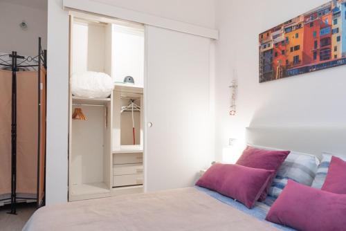 a bedroom with a bed with pink pillows and a closet at la casa di gusto in La Spezia