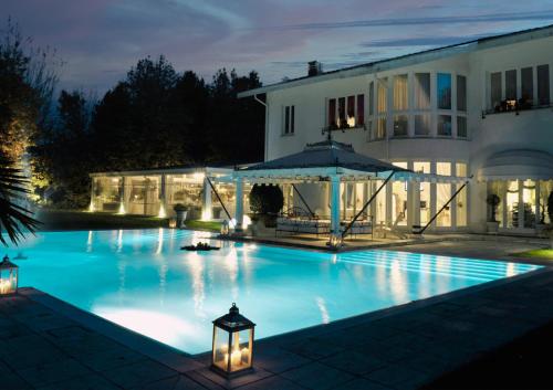 Magnago的住宿－Villa Patrizia B&B，夜间在房子前面的游泳池