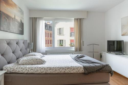 ローザンヌにあるModern apartments in the heart of Lausanneの大きなベッドと窓のある寝室