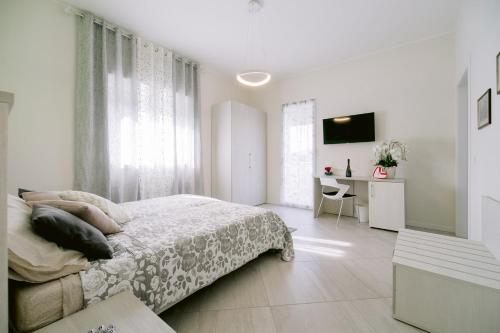 a white bedroom with a bed and a desk at Residenza La Boheme in Verona