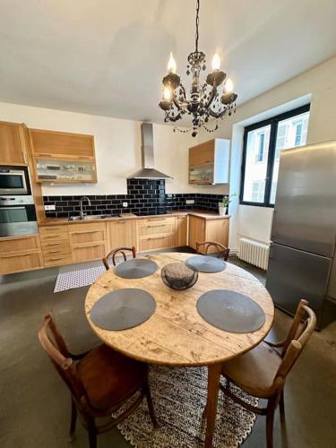 une cuisine avec une table en bois avec des chaises et un réfrigérateur dans l'établissement Appartement chaleureux hyper centre, à Meaux