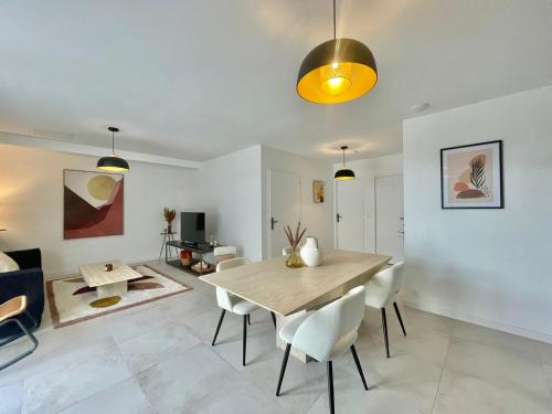 uma sala de jantar com uma mesa de madeira e cadeiras em APPART'ICI Spacieux appartement F3 moderne et chaleureux em Lunel-Viel