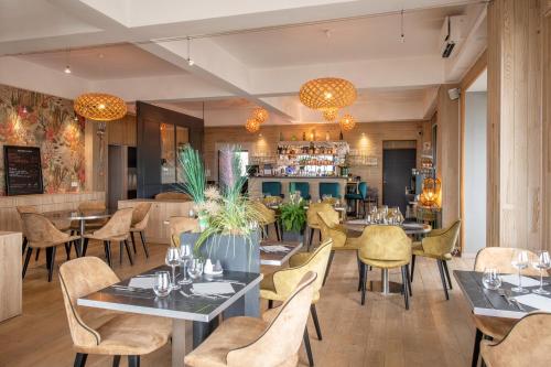 un restaurant avec des tables et des chaises et un bar dans l'établissement The Originals Boutique, Hôtel La Villa Marine, Le Tréport, au Tréport
