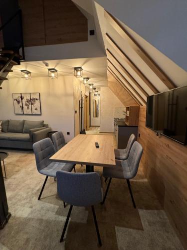 a living room with a wooden table and chairs at Apartments Suncani Vrhovi Kopaonik in Kopaonik