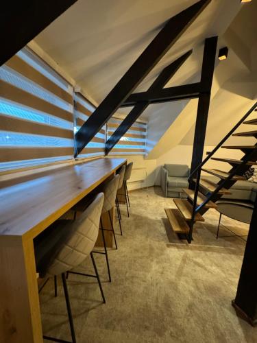 a long table in a room with chairs and stairs at Apartments Suncani Vrhovi Kopaonik in Kopaonik