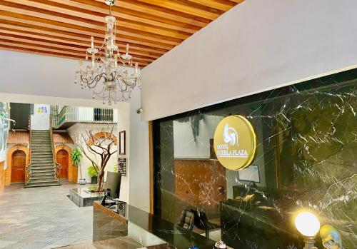 Habitación con lámpara de araña y pared de cristal. en Hotel Puebla Plaza, en Puebla