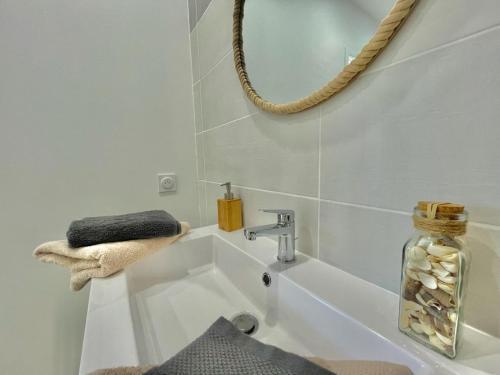 une salle de bain avec un lavabo et un miroir dans l'établissement APPART'ICI 4 - Spacieux appartement F3, à Lunel-Viel