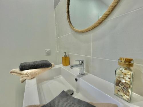 uma casa de banho com um lavatório e um espelho em APPART'ICI Spacieux appartement F3 moderne et chaleureux em Lunel-Viel
