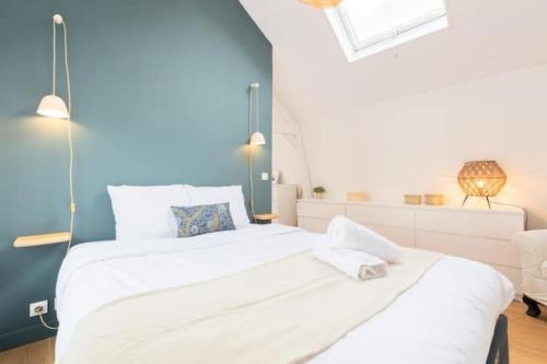 a bedroom with two beds and a blue wall at Lille Citadelle Charming house with courtyard in Lille