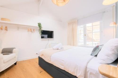 a white bedroom with a large bed and a couch at Lille Citadelle Charming house with courtyard in Lille