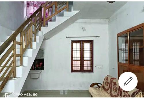 a living room with a staircase and a couch at Sree Paramahamsa in Varkala