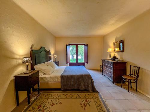 a bedroom with a bed and a dresser and a window at Casa Justininho in Ponte de Lima
