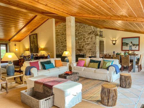 a living room with couches and a stone wall at Casa Justininho in Ponte de Lima