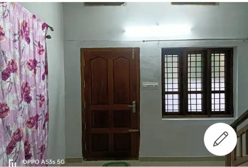 a room with a wooden door and a window at Sree Paramahamsa in Varkala