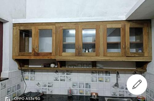a kitchen with wooden cabinets above a counter at Sree Paramahamsa in Varkala