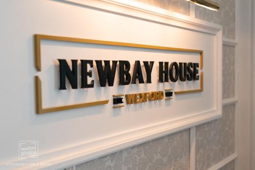 a neway house sign on a wall in a bathroom at Newbay House Wexford in Wexford