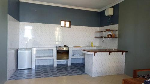 MINAZI BEACH BUNGALOWS في نونغوي: مطبخ فيه موقد وكاونتر