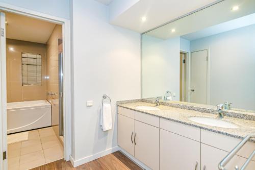 a bathroom with two sinks and a large mirror at SEA VIEW HOTEL APART in Baku