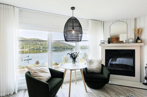a living room with a table and chairs and a large window at Les Lofts du Lac des Sables by Gestion ELITE in Sainte-Agathe-des-Monts