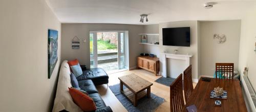 a living room with a couch and a table at Ryde Beach Garden Apartment in Ryde