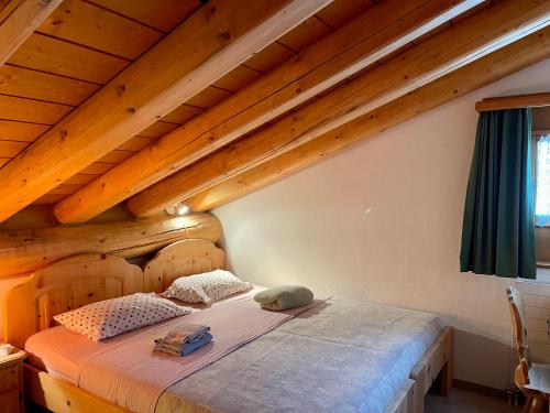 Bett in einem Zimmer mit Holzdecken in der Unterkunft Chalet near St.Moritz in Madulain