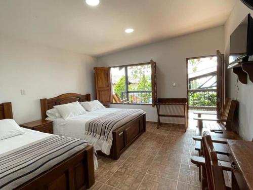 Кровать или кровати в номере Hotel Bosques Del Saman Alcala