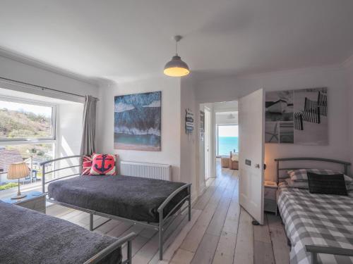 a bedroom with two beds and a view of the ocean at Brigydon Tresaith in Penbryn