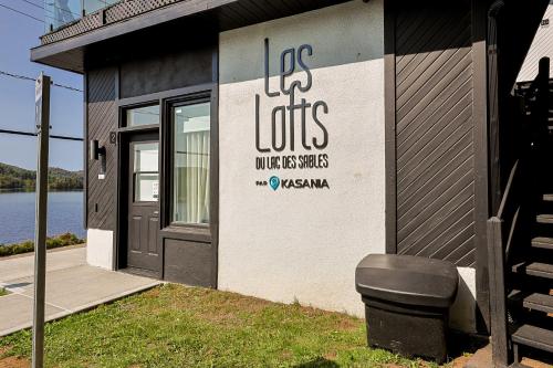 a building with a sign on the side of it at Les Lofts du Lac des Sables by Gestion ELITE in Sainte-Agathe-des-Monts