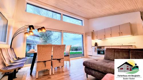 a living room with a table and a couch at Exklusives Holzhaus mit Bergbahn - Baden-Baden im Schwarzwald in Baden-Baden