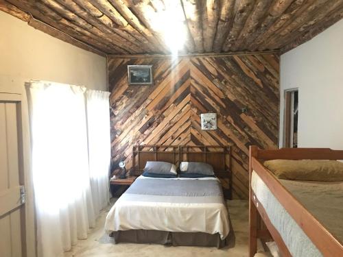 a bedroom with a bed and a wooden wall at Dullstroom on the Dam Backpackers in Dullstroom