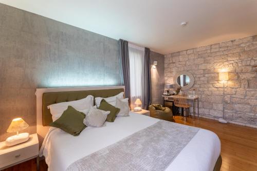 a bedroom with a large bed with a stone wall at Hotel San Giorgio in Vis
