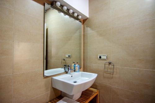 y baño con lavabo y espejo. en RentalSevilla en Plaza de los Terceros, en Sevilla