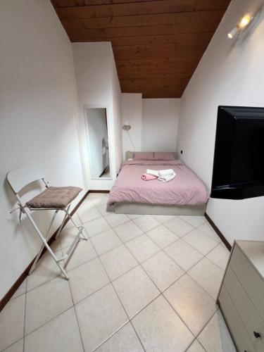 sypialnia z łóżkiem, krzesłem i telewizorem w obiekcie Shali wood apartment w mieście Valmadrera